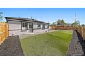 A perfect backyard features newly installed turf, rock, and wood fencing; perfect for entertaining at 3216 Elizabeth, Denver, CO 80205