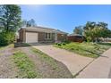 A brick home with a well-maintained lawn and a one-car attached garage on a sunny day at 11320 Irma Dr, Northglenn, CO 80233
