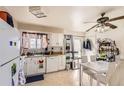 Bright kitchen with white cabinets, a ceiling fan, and a dining area, perfect for casual meals and entertaining at 2108 S Idalia S St, Aurora, CO 80013