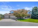 Charming brick home with well-manicured lawn, mature trees, and three-car garage at 7226 Dove Ct, Parker, CO 80134
