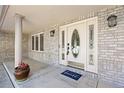 Inviting front porch with elegant door, sidelights, and brick accents at 7226 Dove Ct, Parker, CO 80134