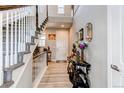 Elegant foyer with hardwood floors, a staircase with white railings, and stylish decor for a welcoming entrance at 14763 Pepper Pike Pl, Parker, CO 80134