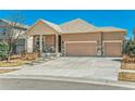 Inviting home featuring a three-car garage, stone accents, and a well-maintained front yard at 6434 N Ensenada Ct, Aurora, CO 80019