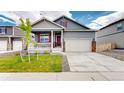 Charming home showcasing a well-kept lawn, two-car garage, and inviting front porch with a striking red front door at 4642 Longs Peak St, Brighton, CO 80601