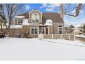 Two-story townhome with snow-covered front yard at 5885 W Atlantic Pl, Lakewood, CO 80227