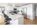 Bright, modern kitchen with white cabinetry, stainless steel appliances, quartz countertops, and island with seating at 2990 E 17Th Ave # 1004, Denver, CO 80206