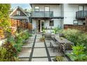 Private backyard featuring a patio with outdoor seating, lush landscaping, and modern concrete paver stones at 3168 W 29Th Ave, Denver, CO 80211