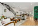 Open-concept living room with hardwood floors, a modern staircase, and a gray sofa at 3168 W 29Th Ave, Denver, CO 80211