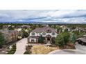 Expansive aerial view showcases the grand home, circular driveway, and lush landscaping against a mountain backdrop at 5167 Morningside Way, Parker, CO 80134