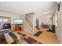 Open-concept living area with hardwood floors, staircase, and adjacent dining area, offering a seamless flow at 1024 S Mobile St, Aurora, CO 80017