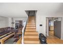 Inviting living room with staircase, cozy fireplace, and seamless flow to the adjacent kitchen at 1024 S Mobile St, Aurora, CO 80017