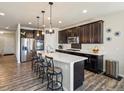 Modern kitchen featuring dark cabinets, stainless steel appliances, and a large center island at 353 Zuniga St, Brighton, CO 80601