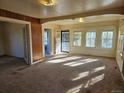 Spacious living room with carpet, wood paneling, and lots of natural light from multiple windows at 16685 W 11Th Ave, Golden, CO 80403