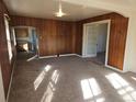 Cozy living room featuring carpet flooring, wood paneling, and multiple windows at 16685 W 11Th Ave, Golden, CO 80403