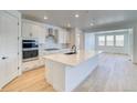 Open kitchen with modern appliances, quartz countertops, island with a black faucet, and spacious layout at 39555 Gwinett Cir, Elizabeth, CO 80107