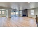 Open living room with fireplace, large windows, and sliding glass doors to the outdoor patio at 39555 Gwinett Cir, Elizabeth, CO 80107