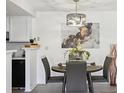 Cozy dining area features modern lighting and decor, complemented by a view of the adjacent kitchen at 10263 E Peakview Ave # C202, Englewood, CO 80111