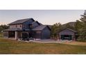 This home features a large backyard with a patio, fire pit, and a detached garage perfect for entertaining or relaxing at 30796 Burland Rd, Golden, CO 80403