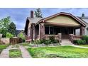 Charming brick home featuring a cozy front porch and well-maintained landscaping at 2835 Cherry St, Denver, CO 80207