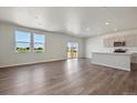 Open-concept living area with hardwood floors, natural light, and access to the backyard at 2169 Flower Blossom Ave, Brighton, CO 80601