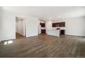 Spacious open-concept living area and kitchen featuring wood floors, modern appliances, and ample natural light at 2169 Flower Blossom Ave, Brighton, CO 80601
