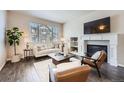 Bright living room with a cozy fireplace, comfortable seating, and a large window at 6777 S Old Hammer Ct, Aurora, CO 80016