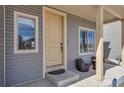 Close up of the front door with a storm door and a cozy chair set on the covered front porch at 5251 Truckee St, Denver, CO 80249