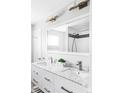 Elegant bathroom featuring a double sink vanity with marble countertop, modern faucets, and a large mirror reflecting the shower at 11354 Allendale Dr, Arvada, CO 80004