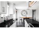 Modern kitchen with sleek black countertops, stainless steel appliances, and a stylish eat-in area at 11354 Allendale Dr, Arvada, CO 80004