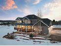 Charming two-story home with a wrap-around porch and attached two-car garage, complemented by beautiful landscaping at 931 Forest View Rd, Monument, CO 80132