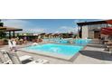 Resort-style pool area with lounge chairs, umbrellas, and a splash fountain for residents' relaxation and recreation at 3768 Backslope Ln, Castle Rock, CO 80108