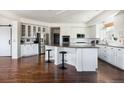 Spacious kitchen with white cabinetry, stainless steel appliances, and an island with bar seating at 17853 W 77Th Ln, Arvada, CO 80007