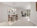 Open living room with dining area, contemporary lighting, and access to the outdoor balcony at 7481 Singing Hills Dr, Boulder, CO 80301