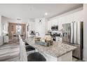 Modern kitchen with white cabinets, granite counters, and breakfast bar at 24747 E Calhoun Pl # C, Aurora, CO 80016