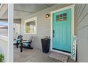 Inviting front porch featuring ample seating, stylish decor, and a bright-colored front door at 2385 S Marion St, Denver, CO 80210
