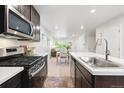 Modern kitchen featuring stainless steel appliances, white countertops, and dark cabinets at 12777 Ulster St, Thornton, CO 80602