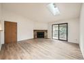 Bright living room with a stone fireplace, a skylight and a sliding glass door to a balcony at 18073 E Ohio Ave # 203, Aurora, CO 80017