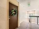 Apartment hallway with stairs, brown door with a wreath, and an exit sign at 7755 E Quincy Ave # 301A7, Denver, CO 80237