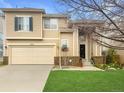 Charming two-story home with a well-maintained lawn, a two-car garage, and mature landscaping at 9469 W Ute Dr, Littleton, CO 80128