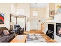 Bright living room featuring high ceilings, large windows, fireplace, and comfortable seating at 9469 W Ute Dr, Littleton, CO 80128