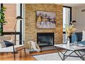 Inviting living room with a stone fireplace, modern artwork, and comfortable seating at 1111 Race St # 6B, Denver, CO 80206