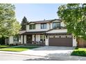Beautiful two-story home featuring an attached garage, white paint, and well-maintained landscaping at 5810 S Galena St, Greenwood Village, CO 80111