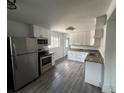 Modern kitchen featuring stainless appliances, granite countertops, white cabinets and wood-look floors at 1550 Eppinger Blvd, Thornton, CO 80229
