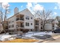 Inviting condo exterior with balconies, stone accents, and well-maintained landscaping on a partially snow-covered ground at 6705 S Field St # 822, Littleton, CO 80128