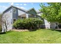 This two-story home boasts a well-maintained lawn and mature trees, showcasing its charming curb appeal at 20234 E Lake Cir, Centennial, CO 80016