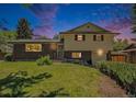 Charming two-story home with a brick facade, complemented by a well-manicured lawn and lush greenery at 8346 W Woodard Dr, Lakewood, CO 80227