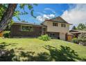 Charming two-story home with a brick facade, complemented by a well-manicured lawn and lush greenery at 8346 W Woodard Dr, Lakewood, CO 80227
