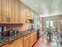 Kitchen featuring wood cabinets, granite countertops, stainless steel dishwasher and wood floors at 3002 E Long S Cir, Centennial, CO 80122