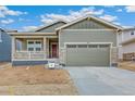 Inviting home with a two-car garage, stone accents, and a covered porch area at 20665 E 57Th Dr, Aurora, CO 80019