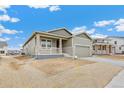 New construction home with stone accents, covered porch, and attached two-car garage at 20665 E 57Th Dr, Aurora, CO 80019